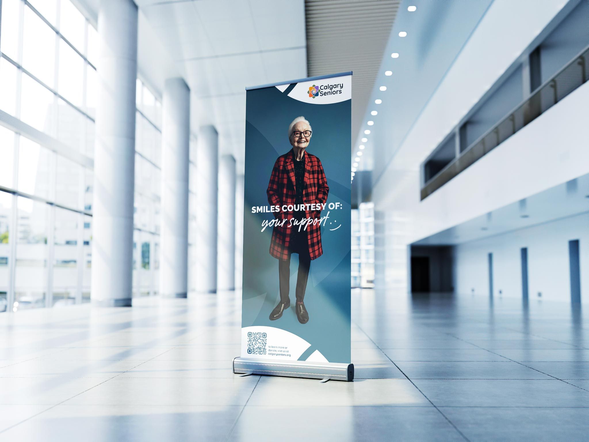 A large banner showing an elderly woman with the text 'Smiles courtesy of your support'